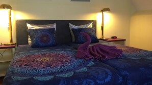 A bed with patterned bedding, two bedside lamps, and a clock on the nightstand. - Hotel De Weyman (Santpoort-Noord)