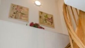 A wooden staircase with a white wall and two framed pictures above it.
