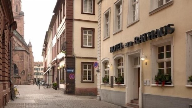 A cobblestone street with a building labeled "HOTEL RATHAUS".