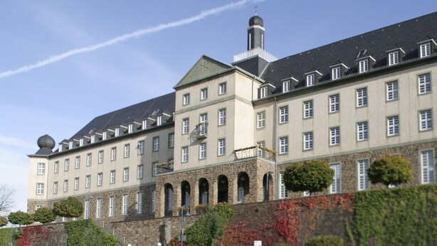Un grand bâtiment historique doté de nombreuses fenêtres et d’une tour imposante.