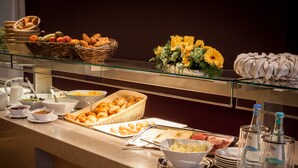 Un buffet proposant une variété de plats, notamment des fruits, des pâtisseries et des boissons.