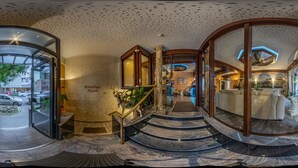 A hotel lobby with a marble staircase, a breakfast room, and a reception area. - Hotel Astro (Stuttgart)