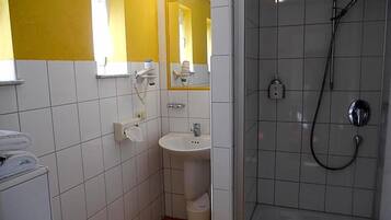 A bathroom with a shower, sink, and mirror.