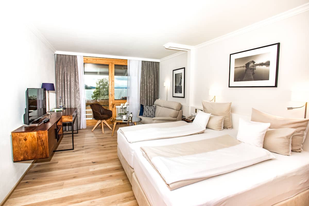 Une chambre d’hôtel avec deux lits, un bureau, une chaise et une vue sur l’extérieur.
