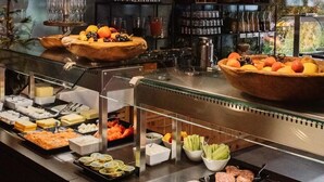 Een ontbijtbuffet met diverse gerechten en uitzicht op het buitengebied.