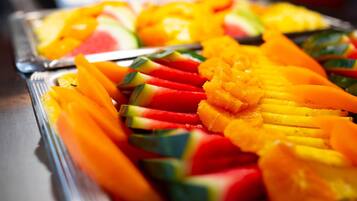 A buffet with various fruits like watermelon, mango, and pineapple.