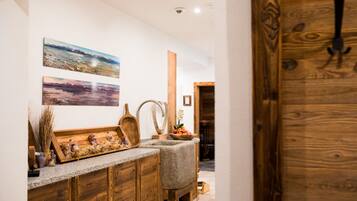A kitchen with wooden cabinets, granite countertops, and a wooden door.
