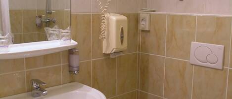 A bathroom with a sink, toilet, and a mirror.