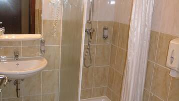 A bathroom with a shower, sink, and toilet.