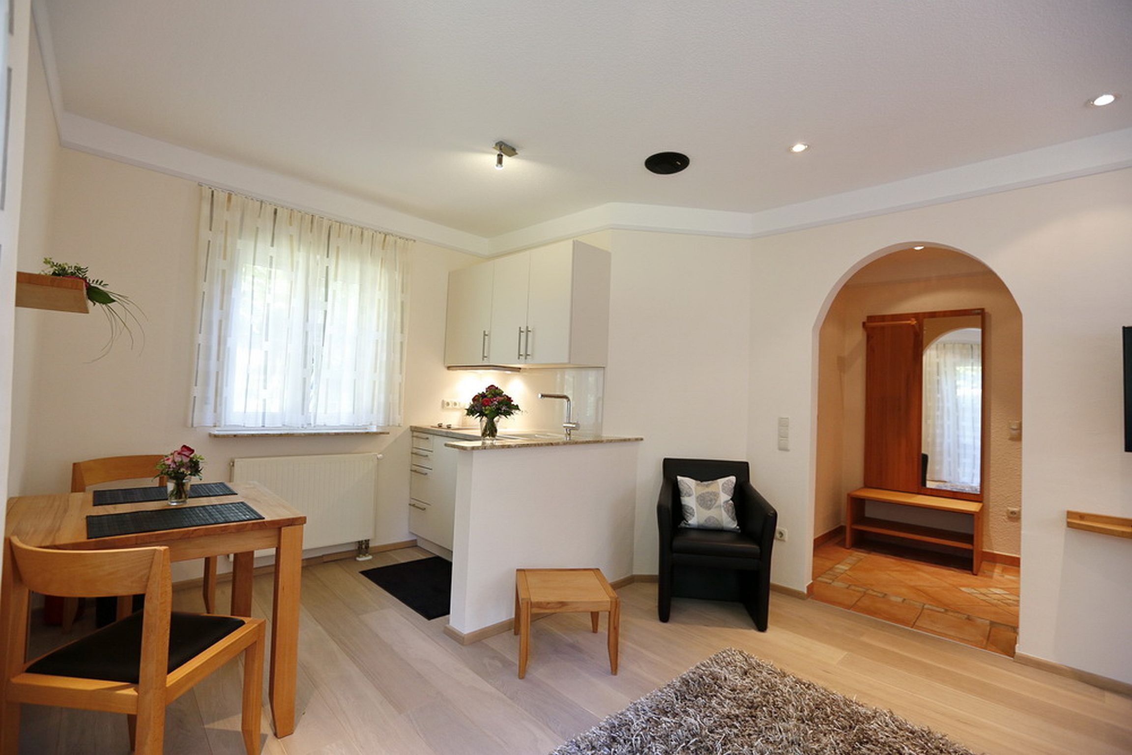 A compact living space with a dining area, kitchenette, and a cozy seating area.