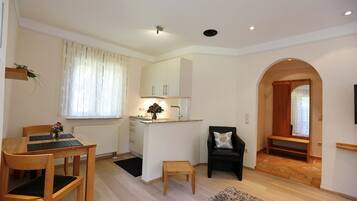 A compact living space with a dining area, kitchenette, and a cozy seating area.