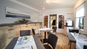 Un comedor moderno con una mesa de madera, sillas y un centro de mesa con planta decorativa.