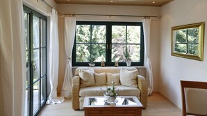 Una habitación acogedora con sofá, una mesa de centro y un ventanal con cortinas.