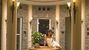 A circular lobby with stone walls, a central seating area, and a door labeled "Sanarium." - Hotel Restaurant Pollmanns (Ernst)