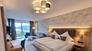 Een hotelkamer met een groot bed, een bureau met stoel, een bank en een televisie.