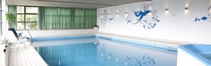 Relax by the serene pool, surrounded by comfortable lounge chairs and beautiful floral art.
