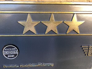 A section of a vehicle with three stars and a badge indicating 'GÜLTIG BIS: DEHOGA 2021'. - Hotel Restaurant Zum Felsenkeller (Sohren)
