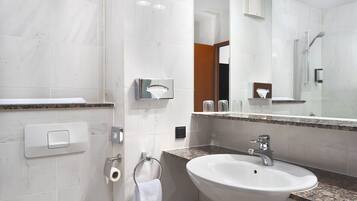 A modern bathroom with a white sink, a mirror, and a towel rack.