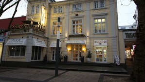 Un hotel con balcón, un cartel que dice "HOTEL" y una tienda con un letrero que dice "DANE AUTOVIREM TUNG".