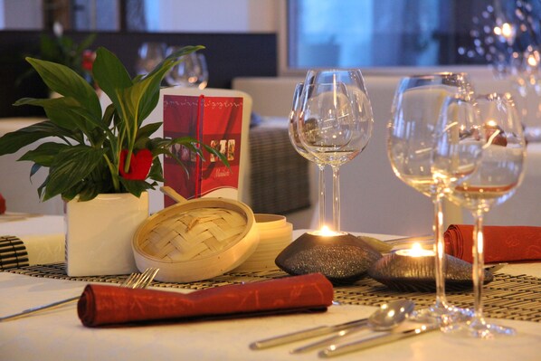 A dining table set with wine glasses, a candle, and a menu. - Hotel Tannhof (Feldberg)
