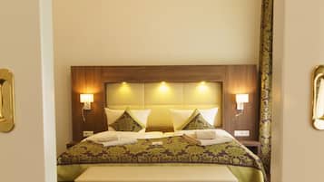 Una habitación de hotel con una cama grande, dos lámparas de noche y un cabecero con iluminación integrada.