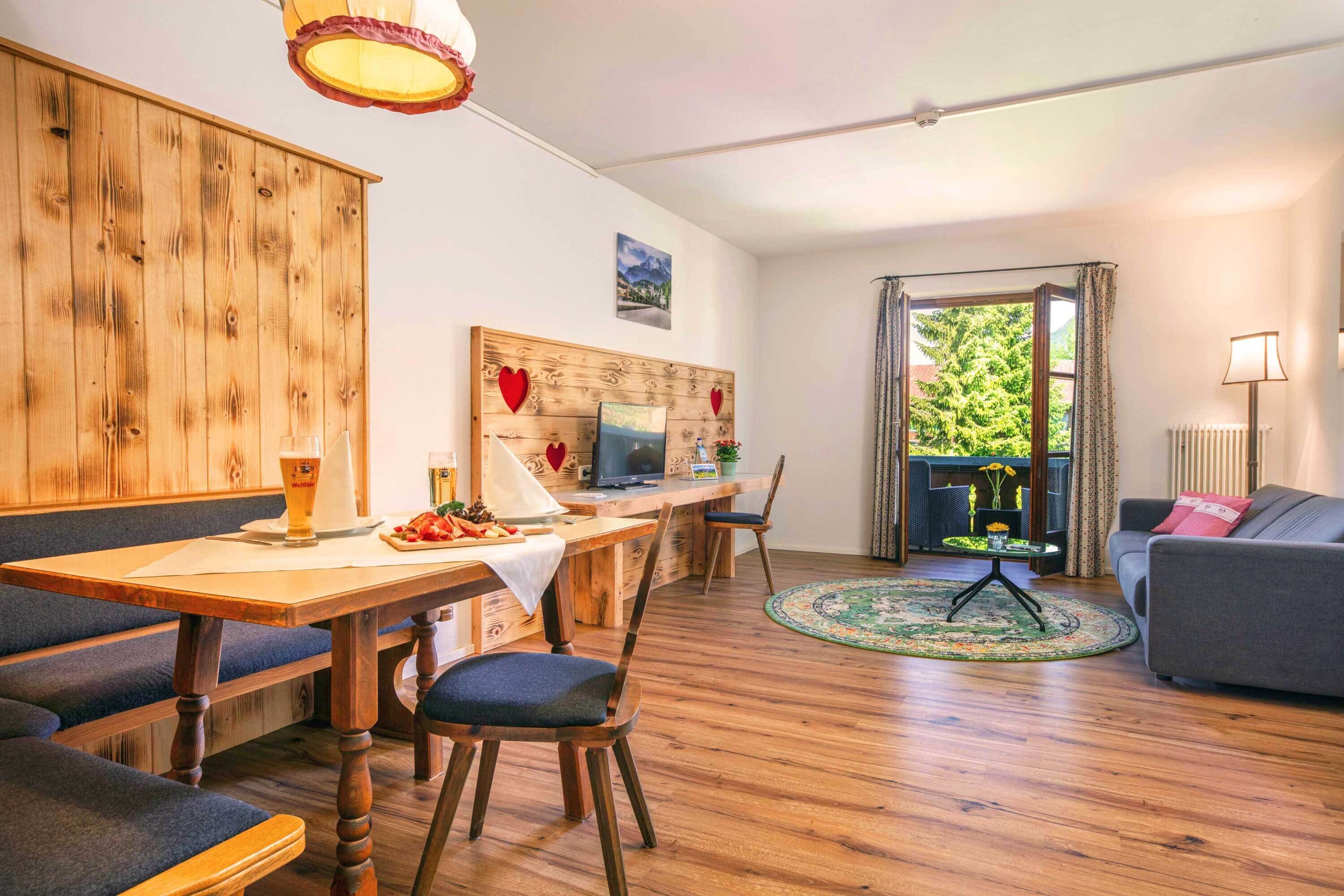 A cozy living room with a sofa, a dining area with a table and chairs, and a TV.