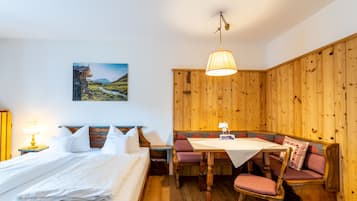 Una habitación con una cama, una mesa y un banco.