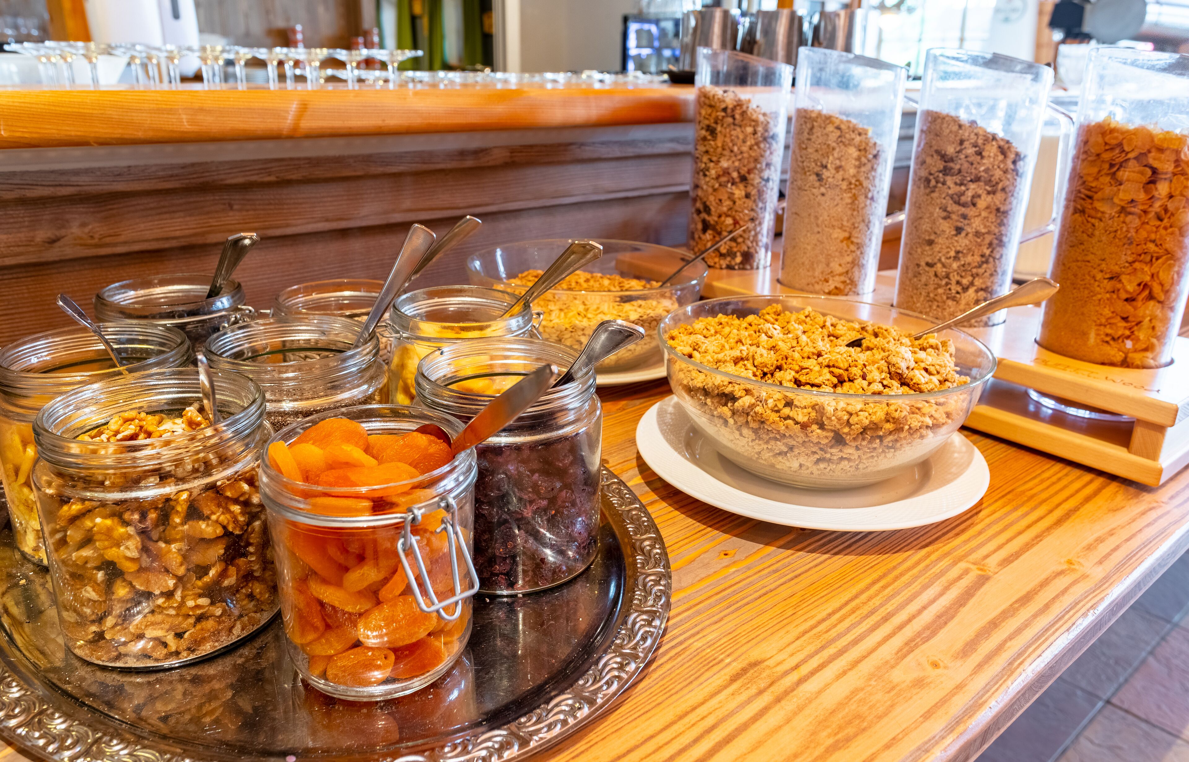 A buffet with various food items including jars of nuts, dried fruits, and granola.