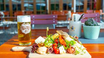 Une table en bois sur laquelle sont disposés divers aliments, ainsi qu’un verre de bière.