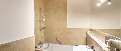 Un baño moderno con bañera, lavamanos y espejo.