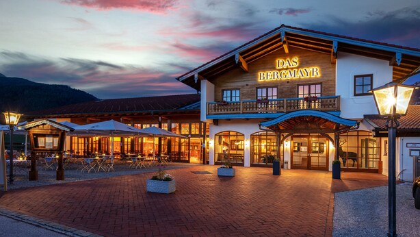 Ein Hotel mit einem Schild, auf dem "DAS BERGMAYR" steht, im Abenddämmerung.
