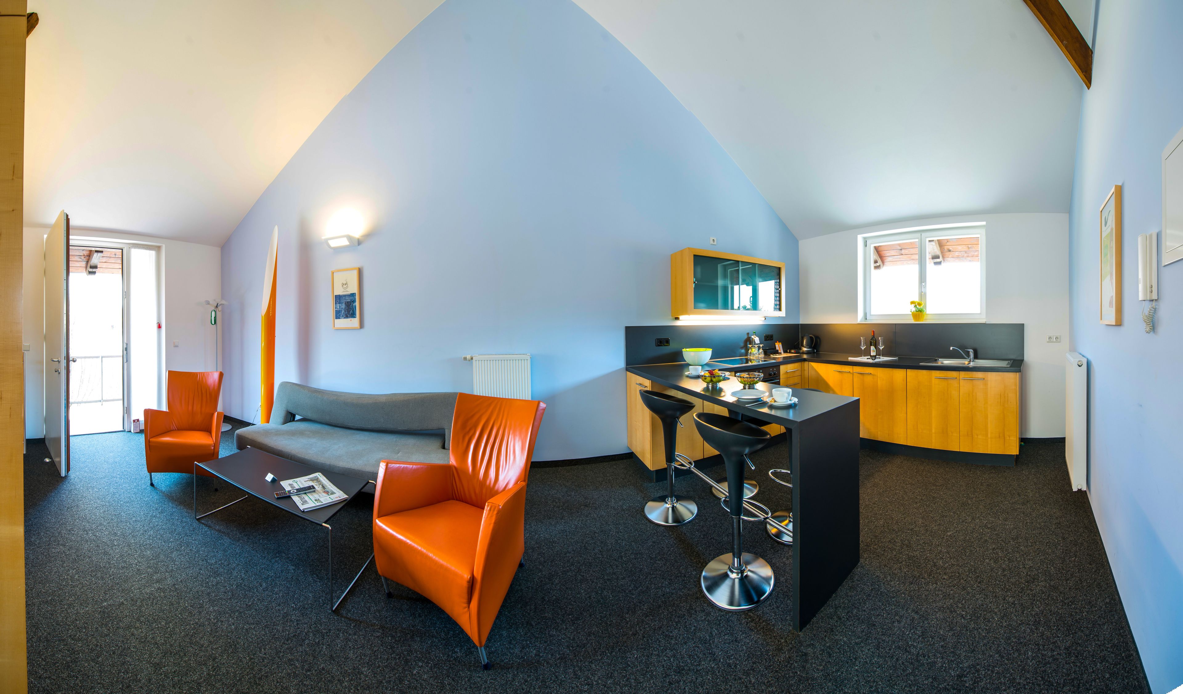 A compact living space with a kitchenette, a sofa, and a dining area.