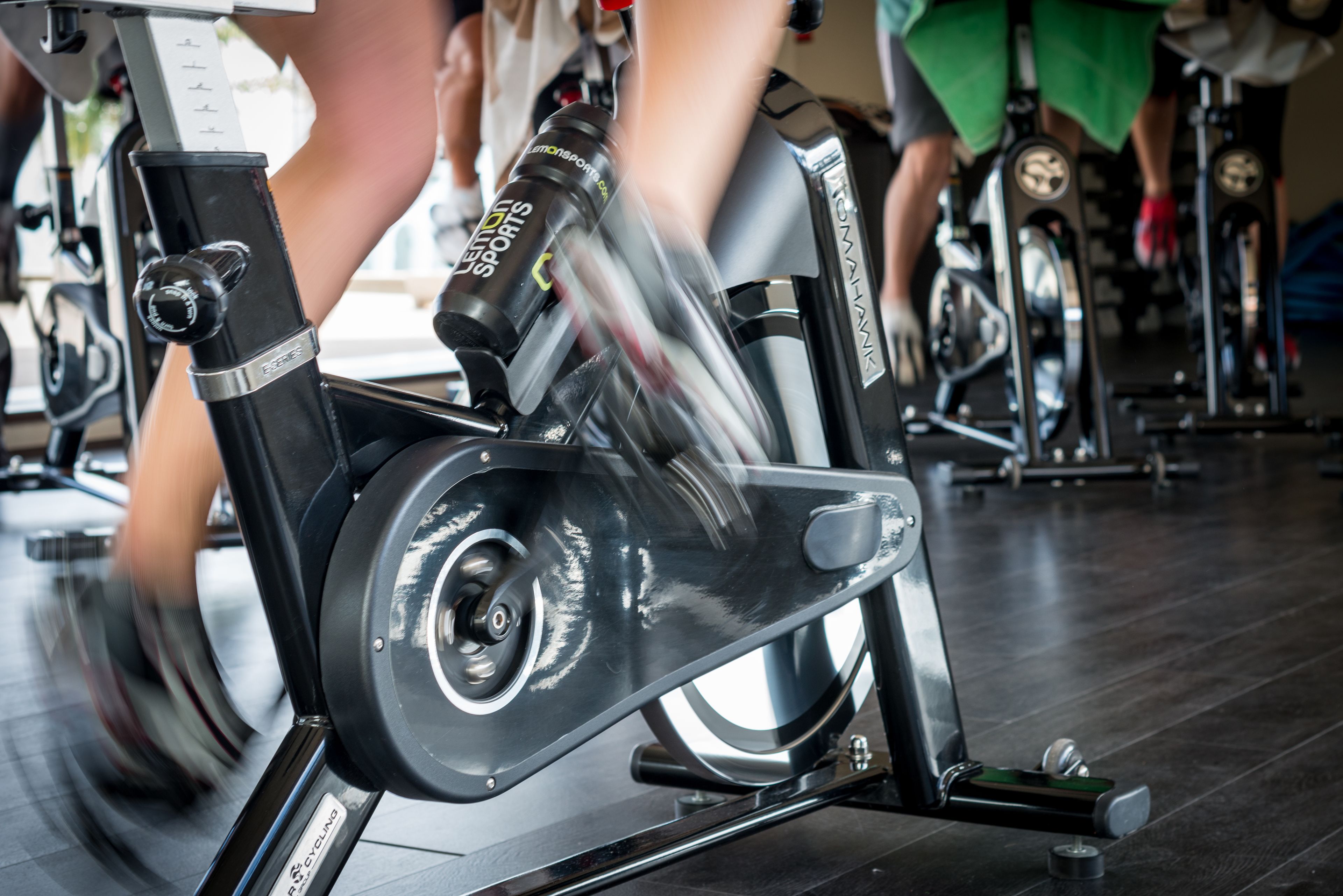 A stationary bike in a gym with a digital display and handlebars.
