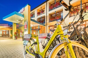Un hotel con un letrero que dice "Best Western PLUS" y una bicicleta amarilla estacionada en la entrada.