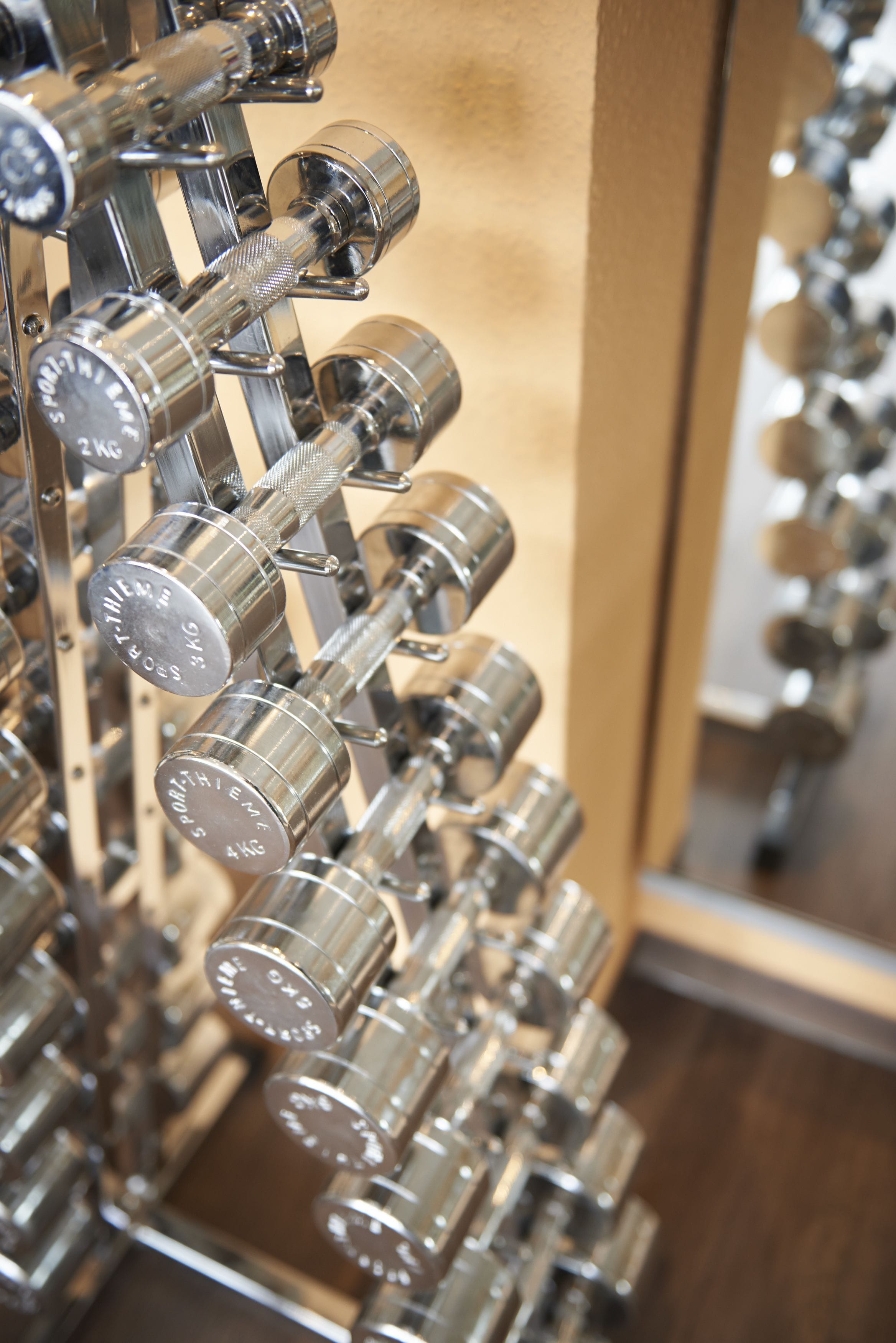 A rack of adjustable dumbbells with weight markings.