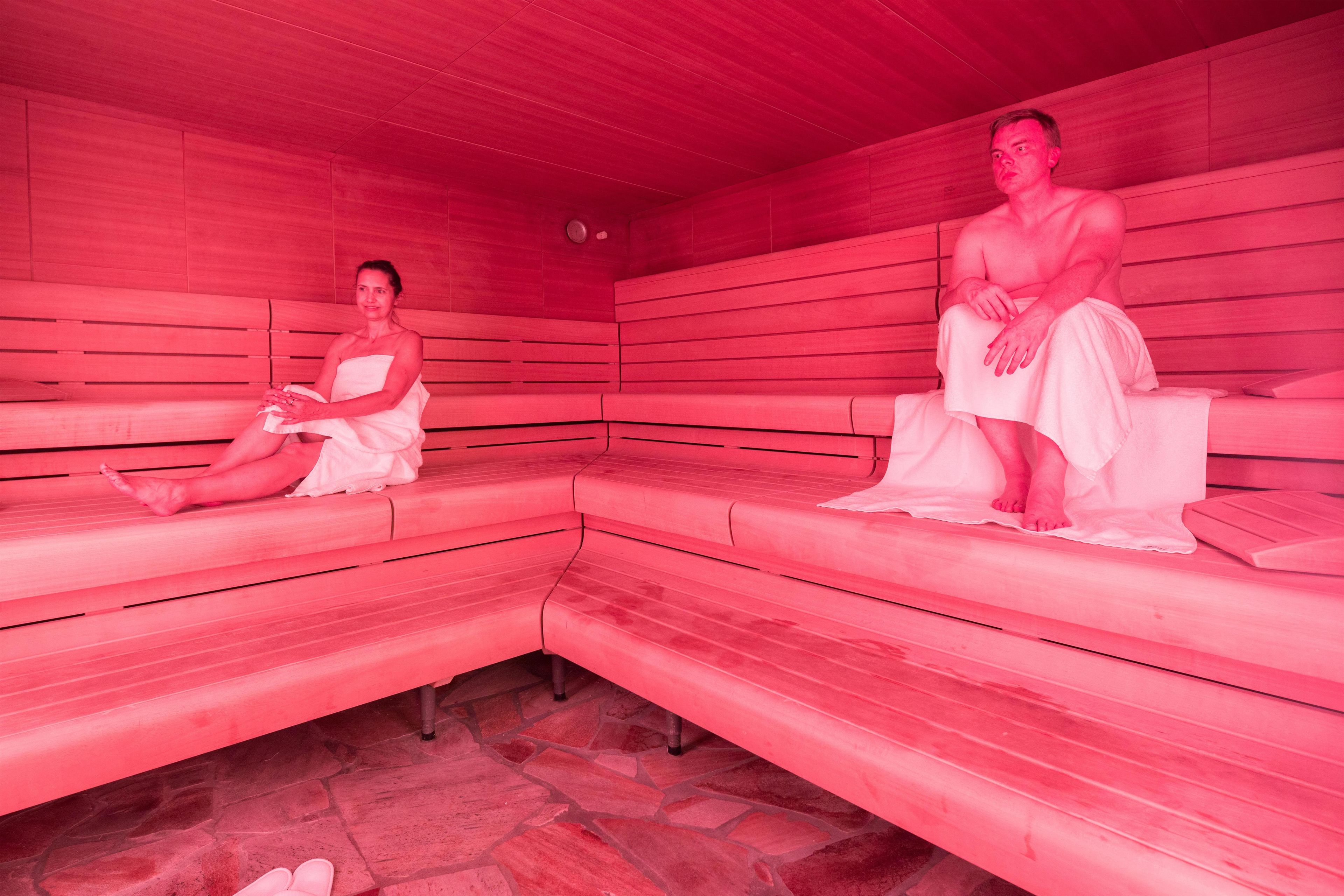 Un sauna avec des bancs en bois et un sol en pierre.