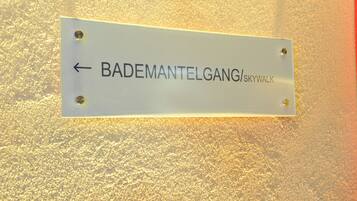 A sign with the text "BADEMANTELGANG/skywalk" and an arrow pointing left.