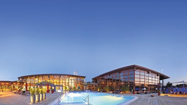 A hotel with a swimming pool, outdoor seating, and a large glass facade. - Best Western Plus Kurhotel an der Obermaintherme (Staffelstein)