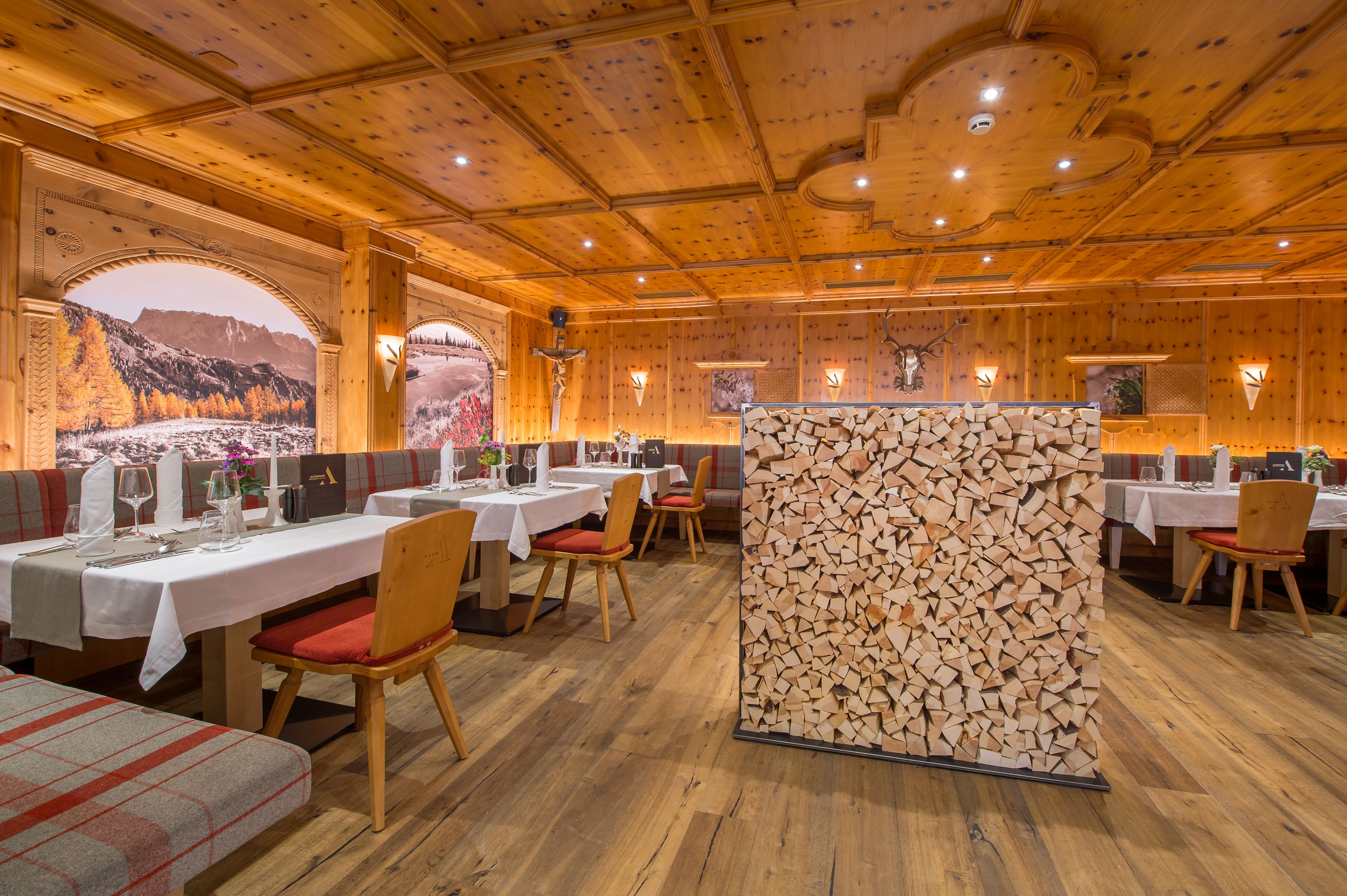 A restaurant with wooden interiors, multiple tables, and chairs.