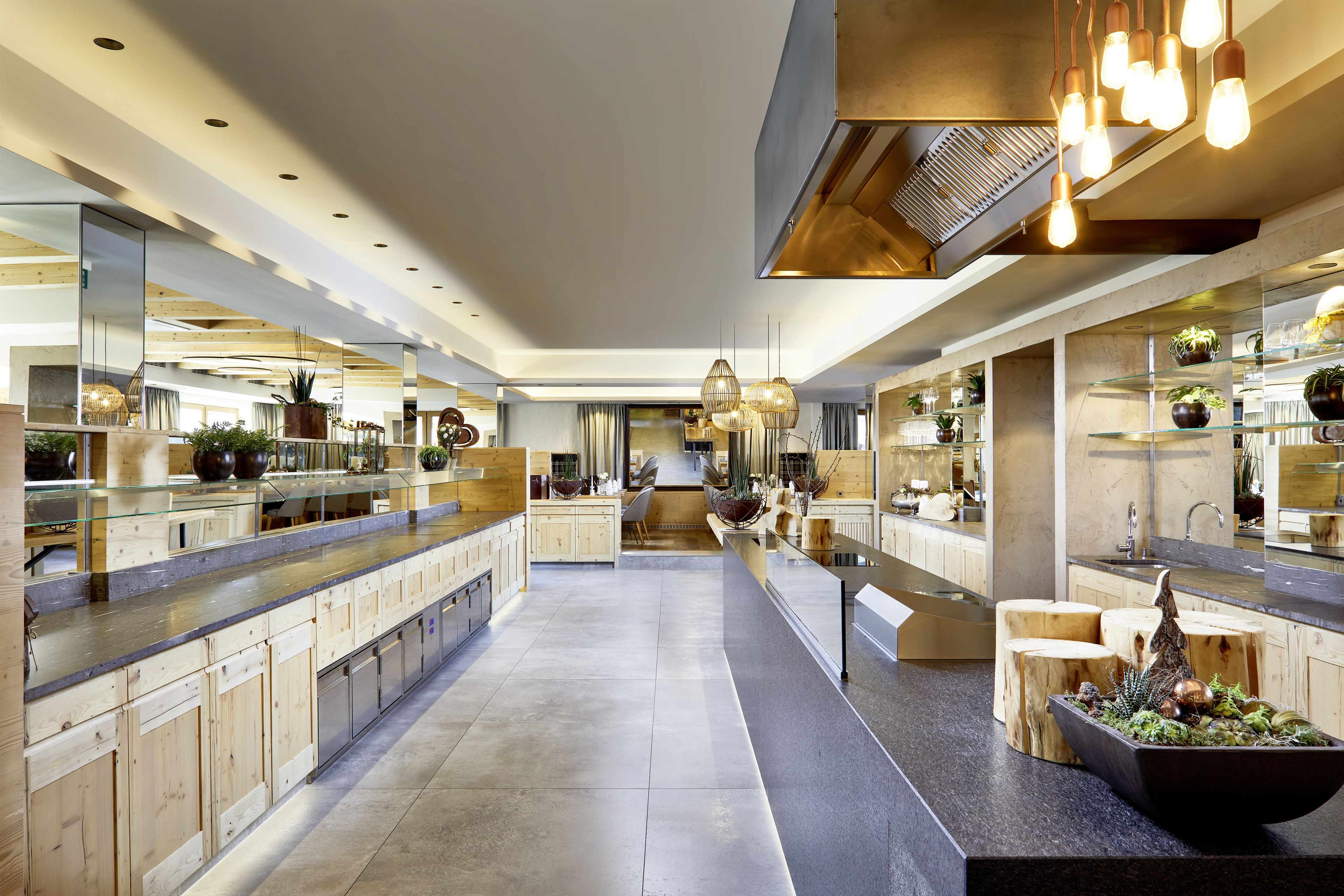 Una cocina moderna con una isla central, armarios de madera y una variedad de plantas.