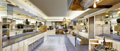 Una cocina moderna con una isla central, armarios de madera y una variedad de plantas.