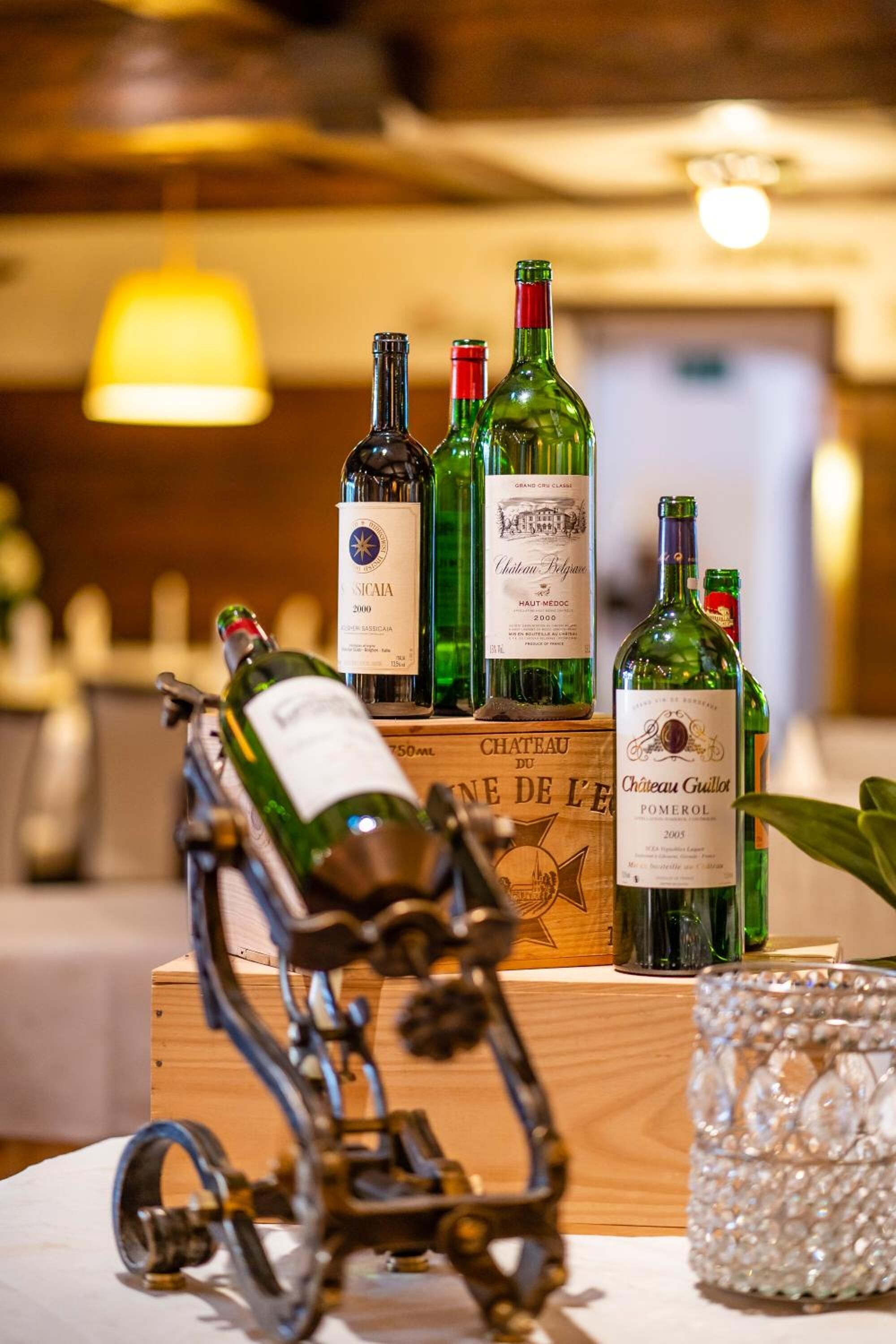 A wooden display with wine bottles and a metal sculpture.