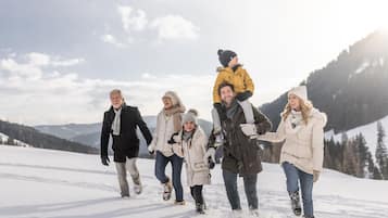 A group of people walking on a snow-covered path in a mountainous area.