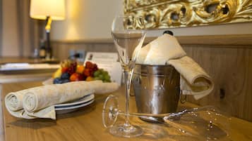 A table with a glass, a napkin, a metal bucket, and a plate of fruit.