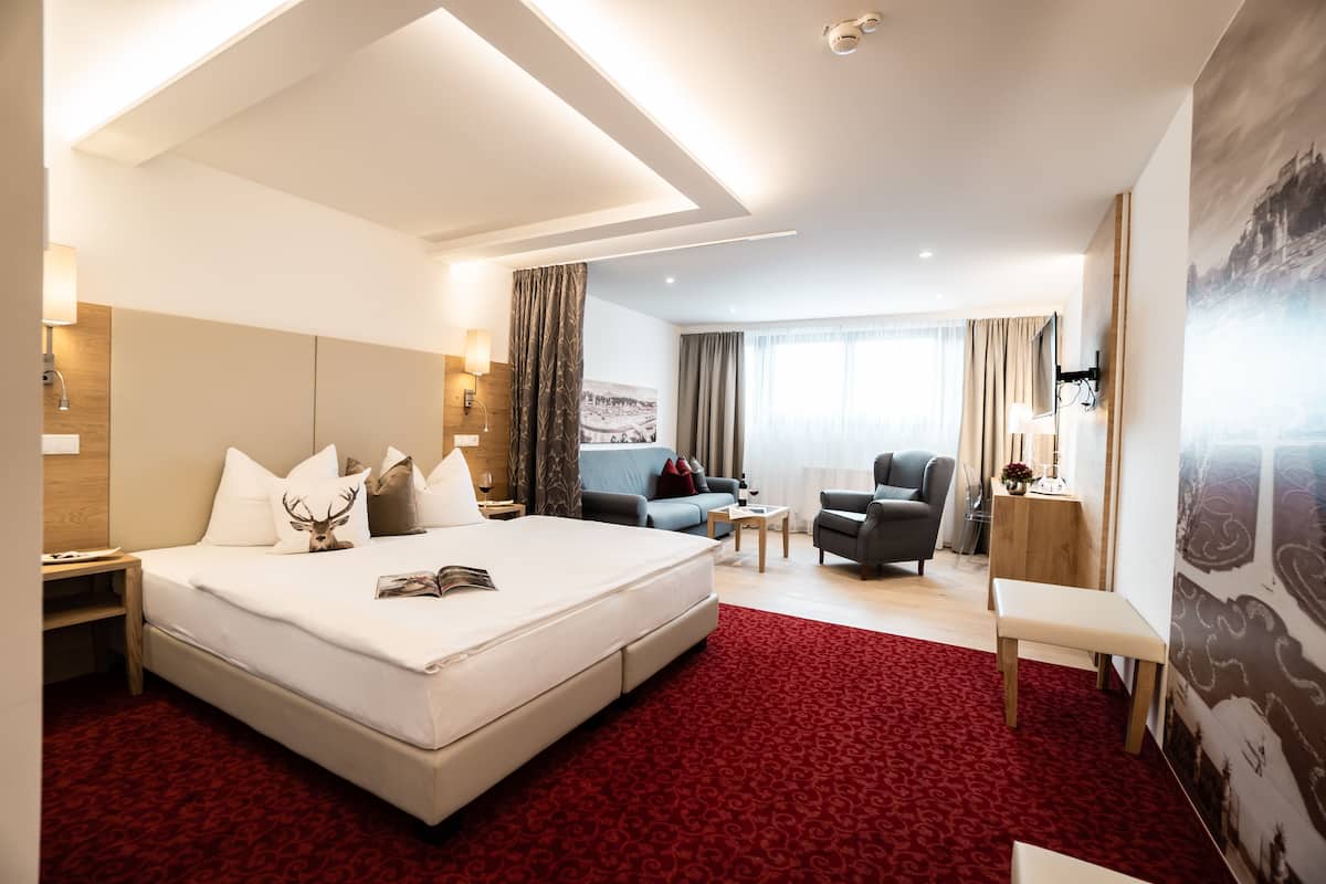 Une chambre d’hôtel moderne, dotée d’un grand lit, d’un canapé, d’un bureau et d’une chaise.