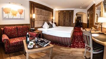 A hotel room with a bed, a sofa, a desk, and a mirror.