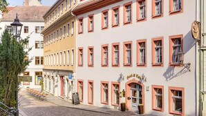 A street with buildings featuring traditional architecture, a cobblestone street, and a sign for a restaurant.
