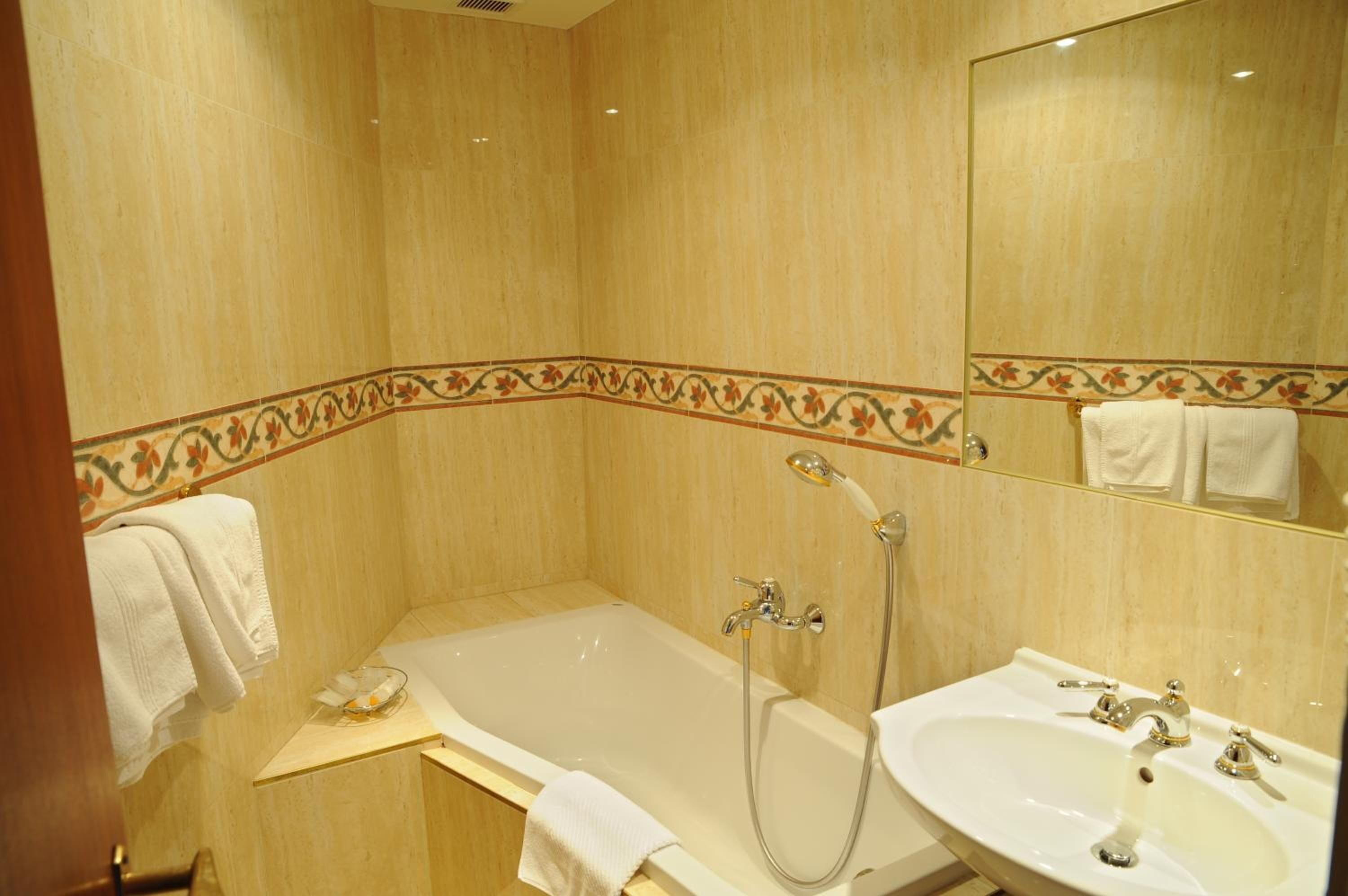 A bathroom with a bathtub, a shower, and a sink.