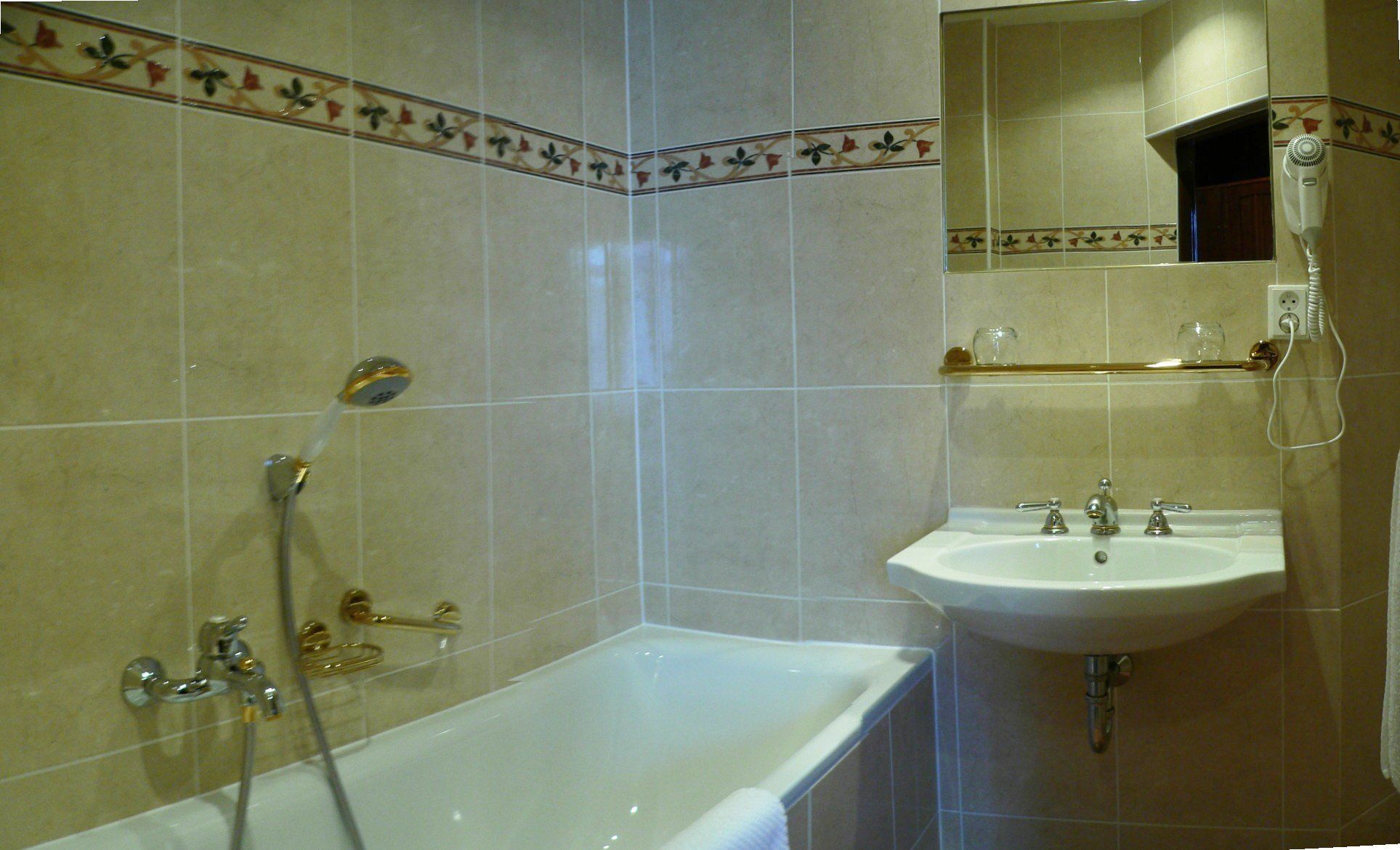 Un baño con bañera, lavamanos y espejo.