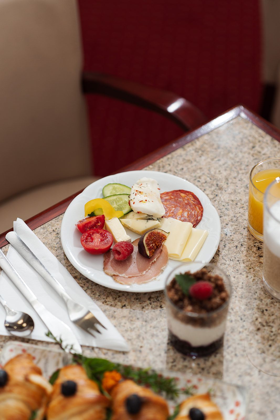 A table with a plate of food, a glass of orange juice, and a dessert.